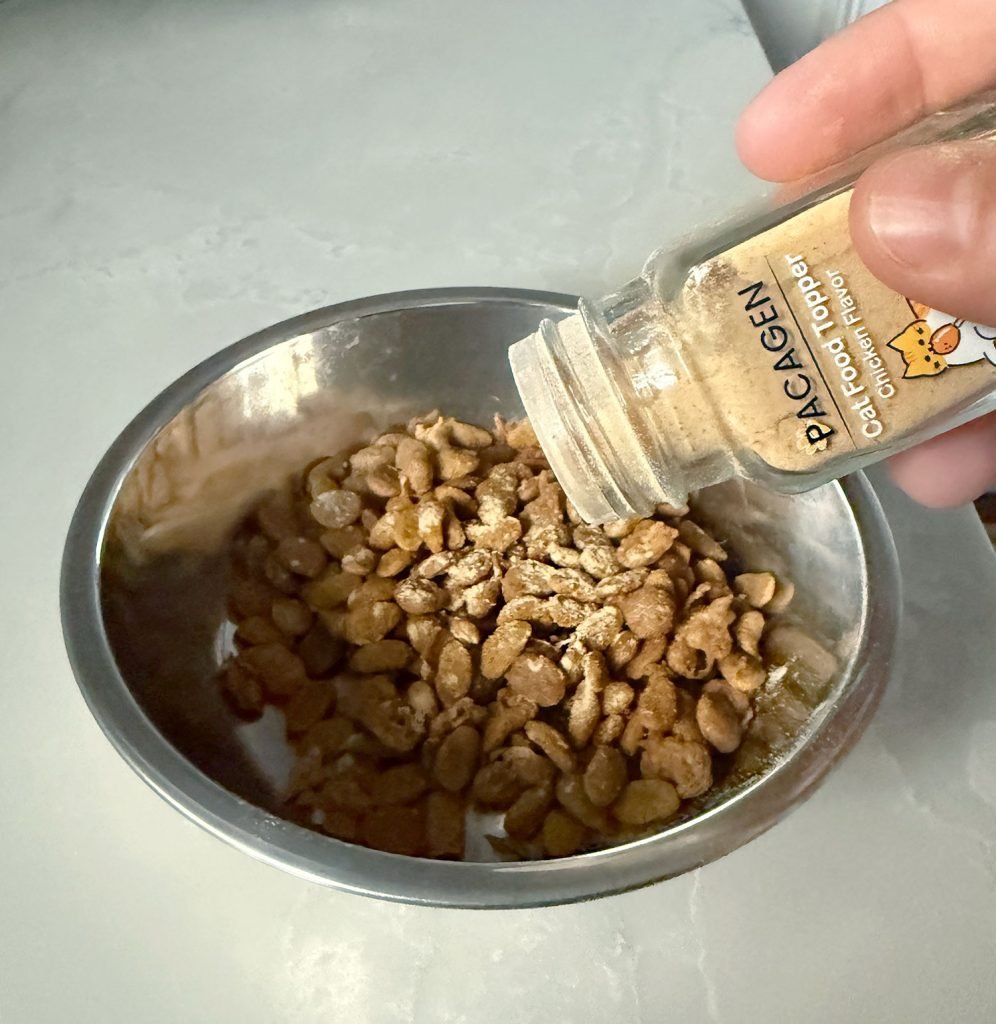 Shaking Pacagen Cat Food Topper on Dry Cat Food