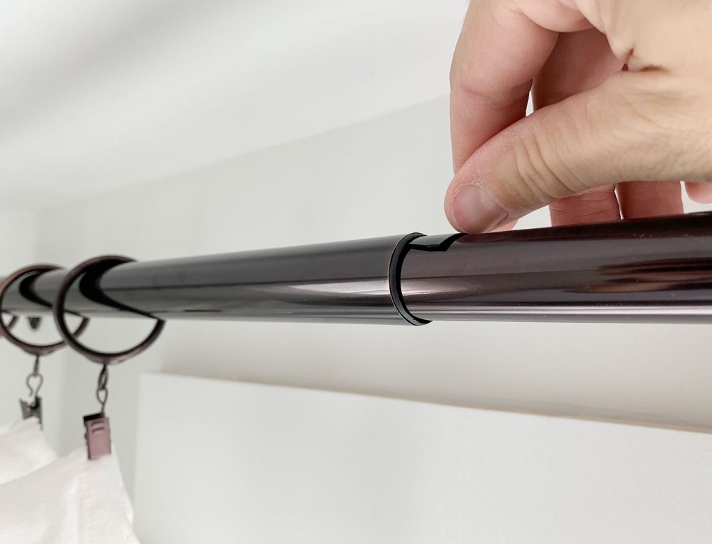 Putting small plastic wedge in curtain rod to prevent sagging