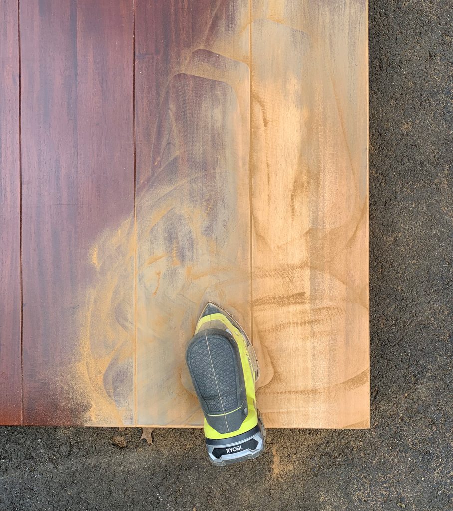 Sanding the finish off of a wood dining table to refinish it with new stain