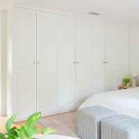Row of Ikea Pax Wardrobe Closets In Bedrom With Gold Knobs
